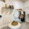 A spacious closet featuring neatly organized clothing items on hangers, shelves with handbags, and a central ottoman